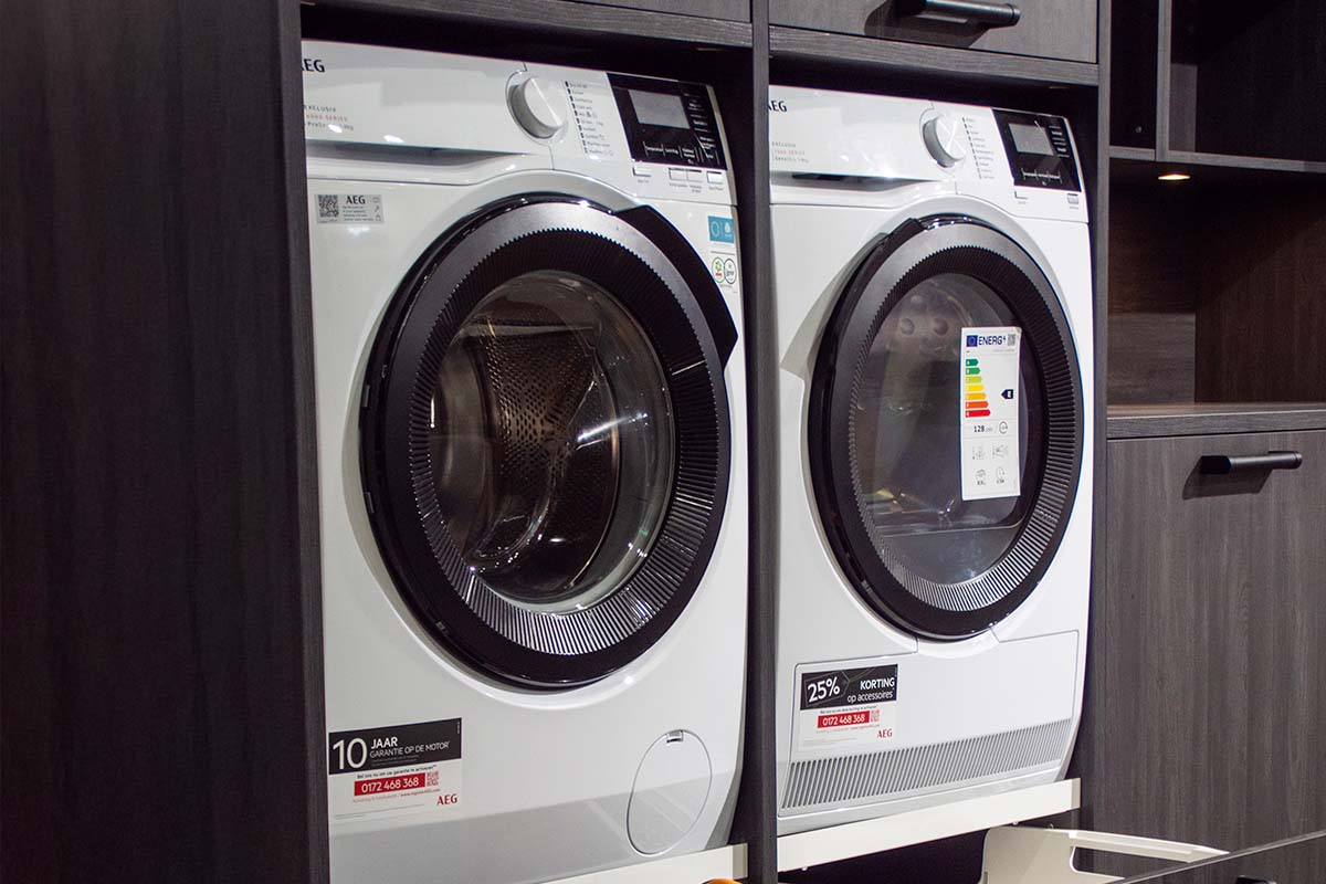 Twee AEG wasmachines in een donkere houten kast