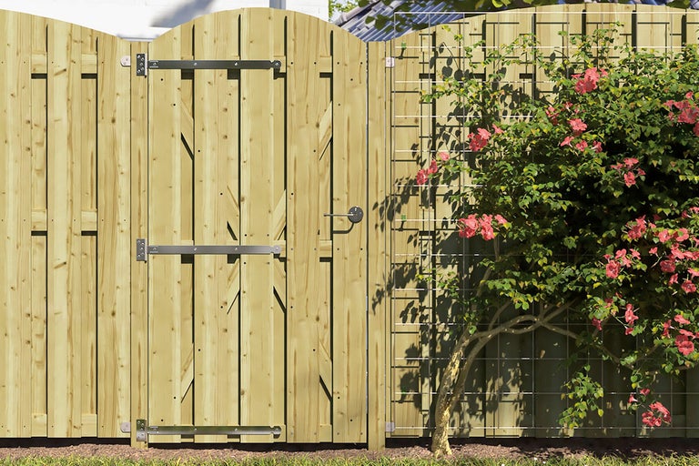 Houten schutting met deur en klimrek met plant