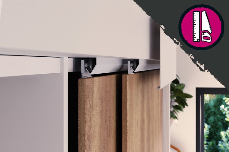 Schuifdeurbeslag op een witte kast met houten deuren