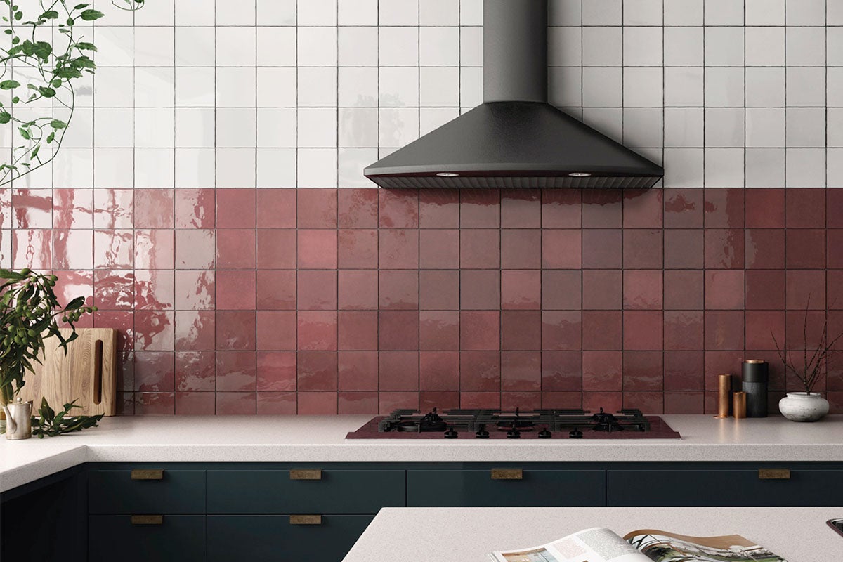 Keukenscène met witte en rode vierkante wandtegels, afzuigkap en keukenmeubels