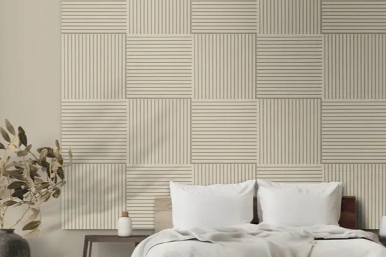 Slaapkamer met akoestische panelen aan de wand en bed op de voorgrond.