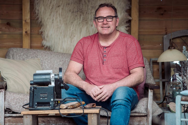 Man zit met draaibank en houtdraaigereedschap in lichte ruimte