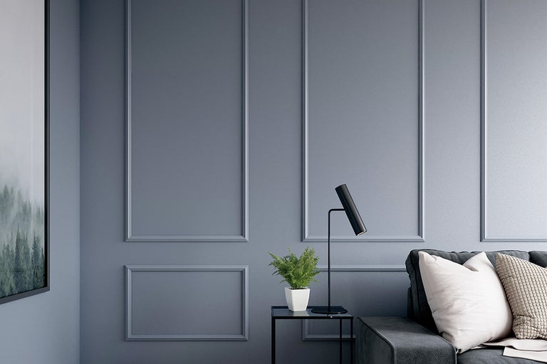 Woonkamer met wandpanelen, bank, tafellamp en decoratie