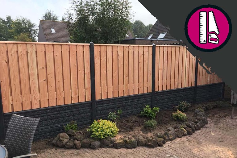 Houten schutting met betonnen fundering in de tuin