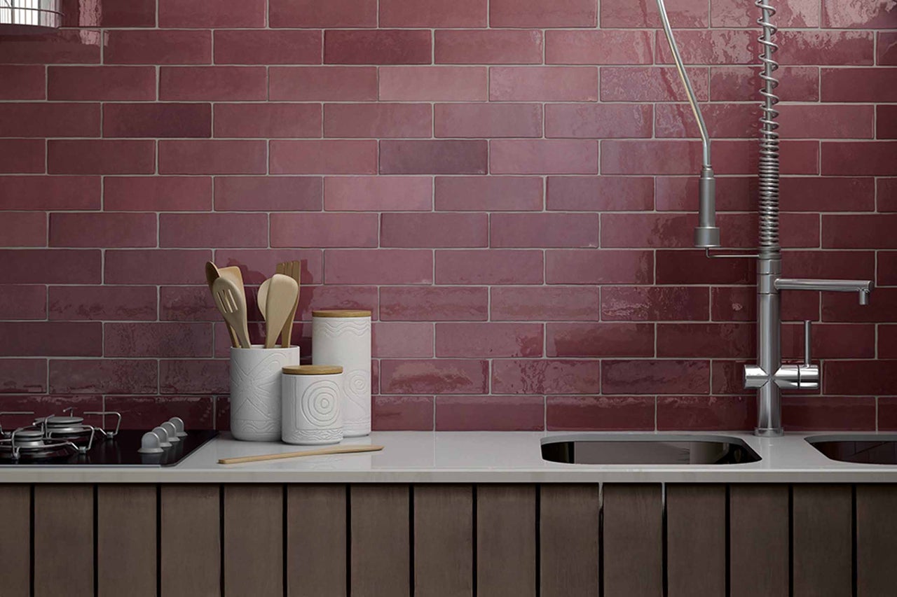 Keukenscène met rode wandtegels in baksteenformaat, spoelbak en keukengerei