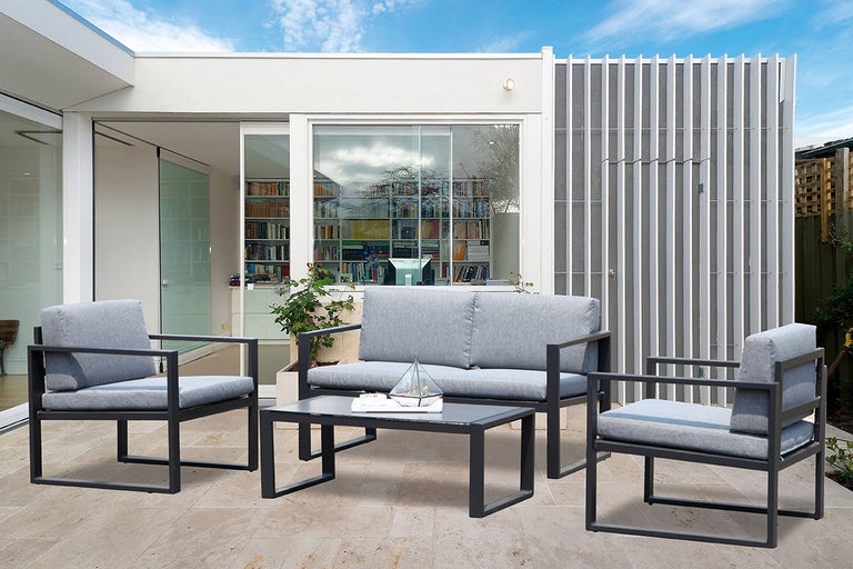 Tuinmeubelset met twee stoelen, een bank en een tafel op een terras