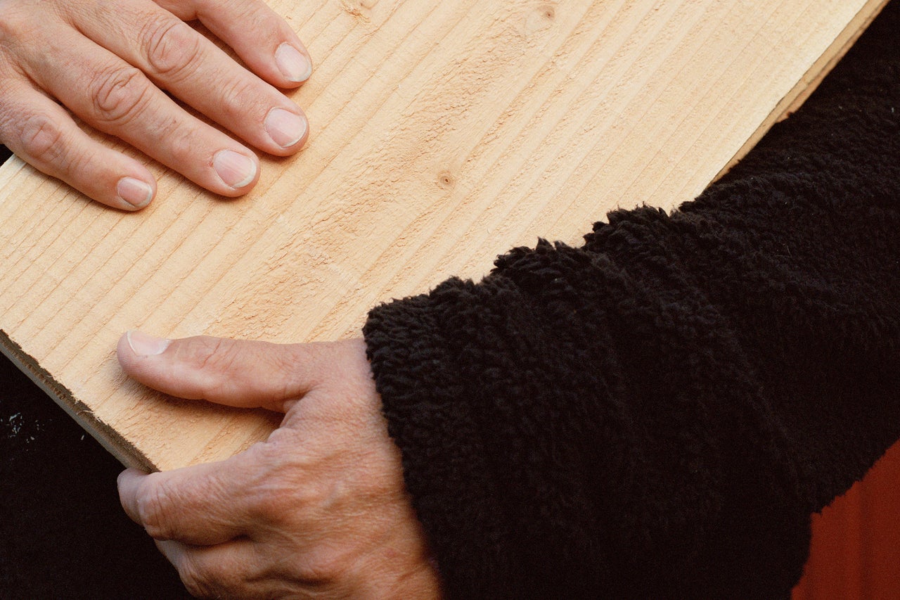 Persoon houdt een houten plank vast