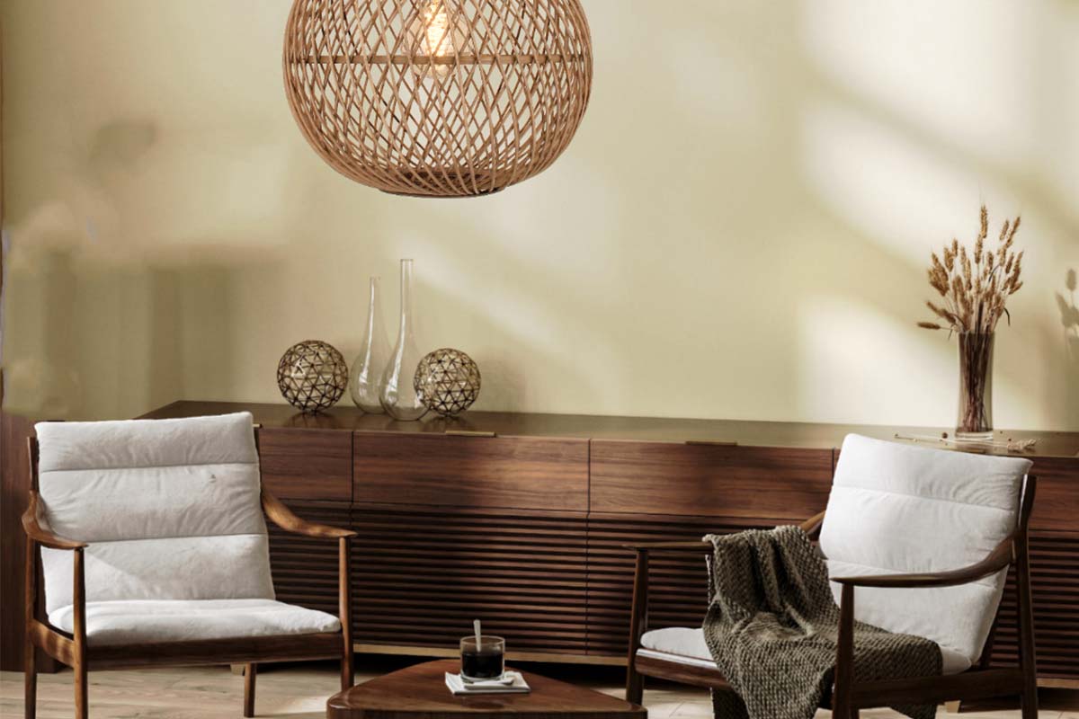 Woonkamer met hanglamp van rotan, houten dressoir en fauteuils