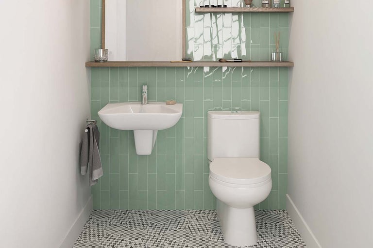 Compacte badkamer met toilet, wastafel en groene tegels