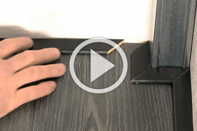 Installatie van plinten op een houten deur met laminaatvloer