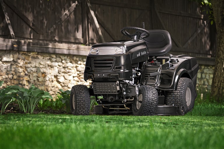 Zitmaaier op gazon voor een tuinhuis