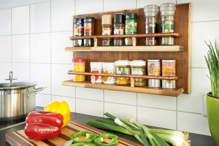 Houten kruidenrek met kruidenpotten aan een betegelde muur in een keuken