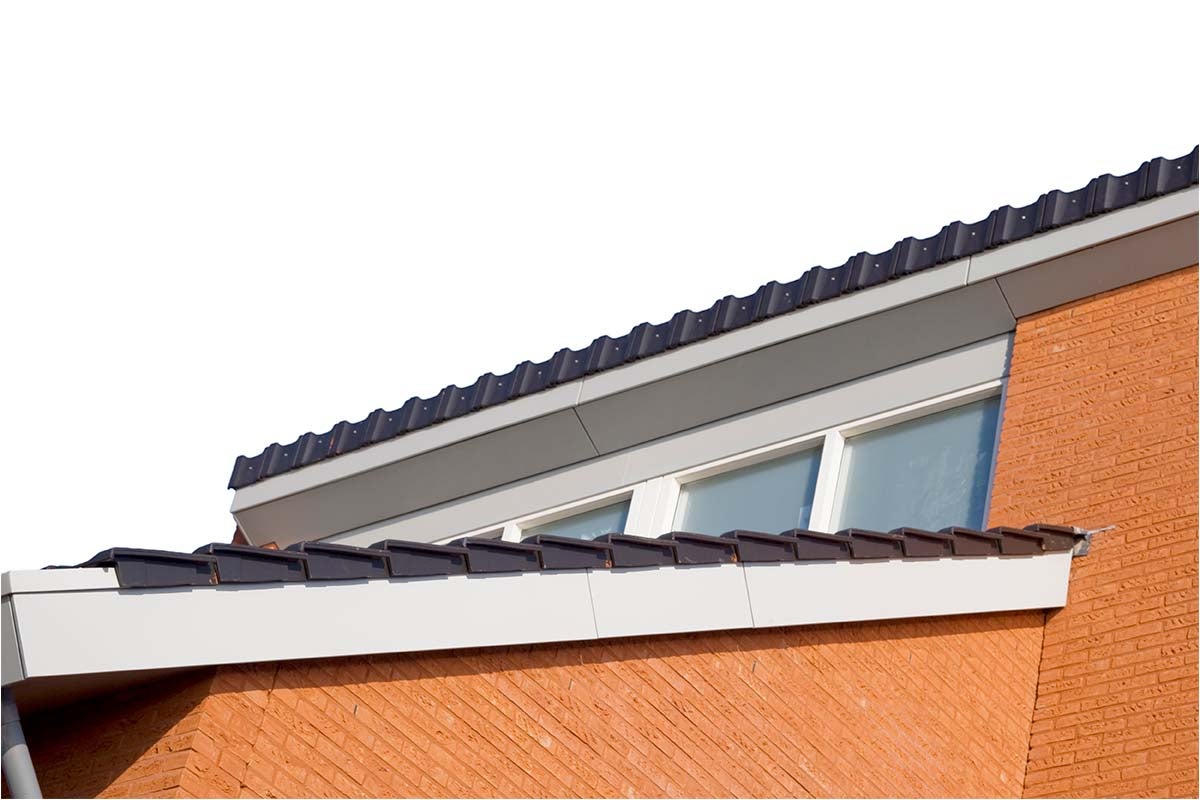 Detailaanzicht van een dak met dakpannen en gevel van een huis van bakstenen