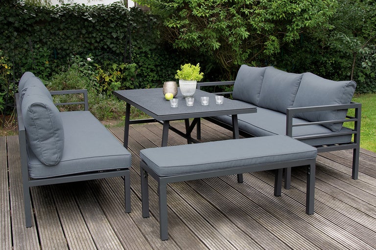 Tuinmeubelset met bank, bank en tafel op een houten terras