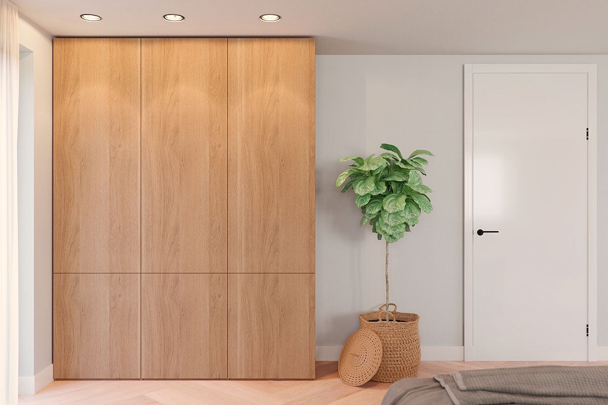Slaapkamer met grote houten kast, kamerplant en deur