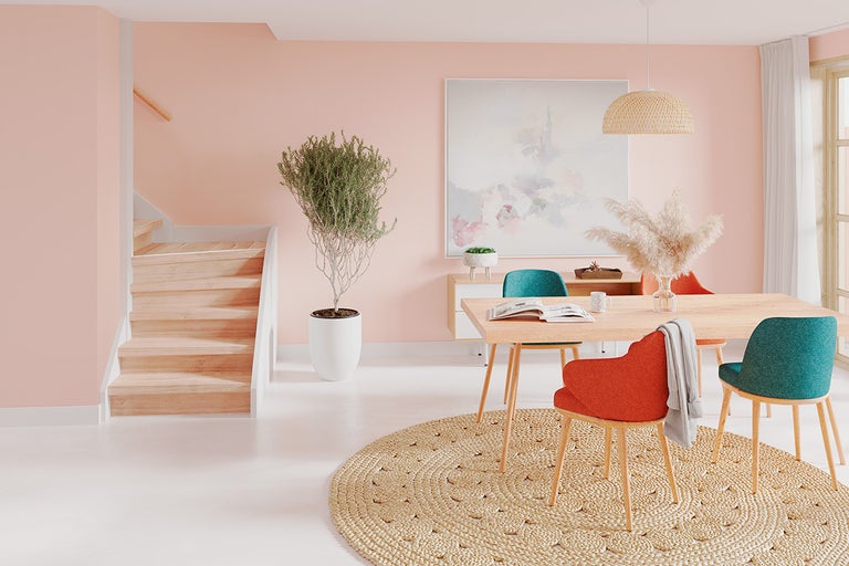 Lichte ruimte met trap, eettafel, stoelen, vloerkleed en decoratie voor een gezellige sfeer.