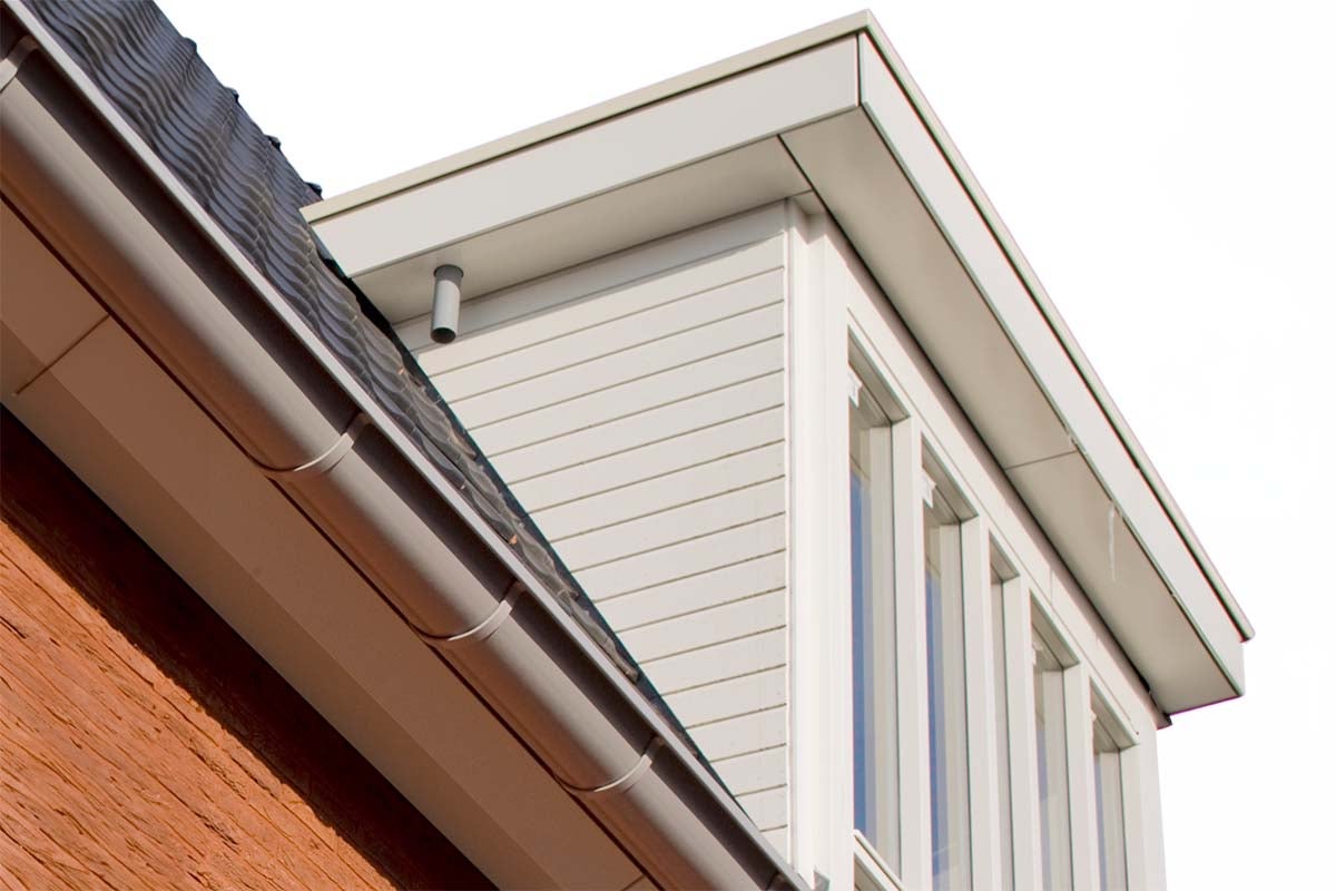 Detailopname van een huis met dakgoot, gevelbekleding en ramen