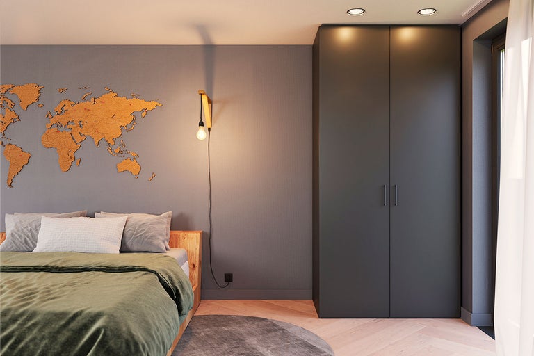 Slaapkamer met bed, wereldkaart aan de muur en kledingkast