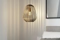 Moderne metalen hanglamp met een korfachtige lampenkap boven een bed in een lichte slaapkamer.