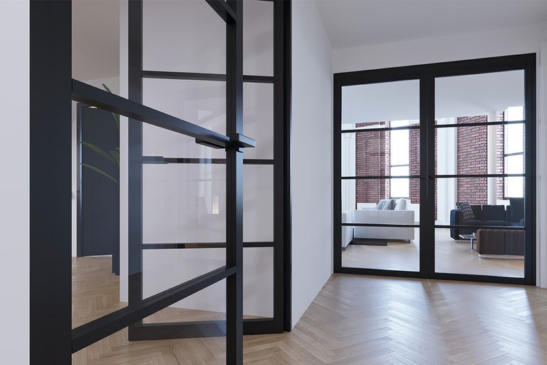 Zwarte stalen deur met glazen panelen in een moderne woonkamer.
