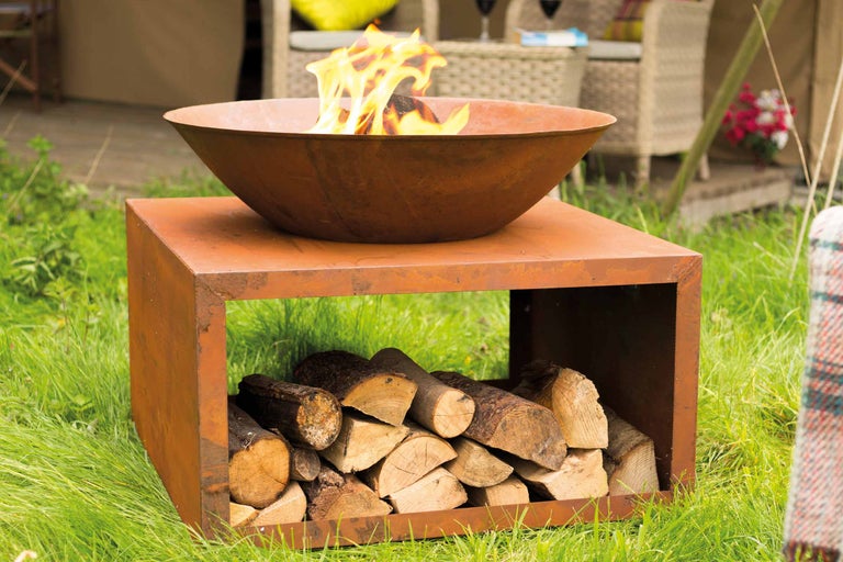 Vuurschaal met houtopslag voor de tuin