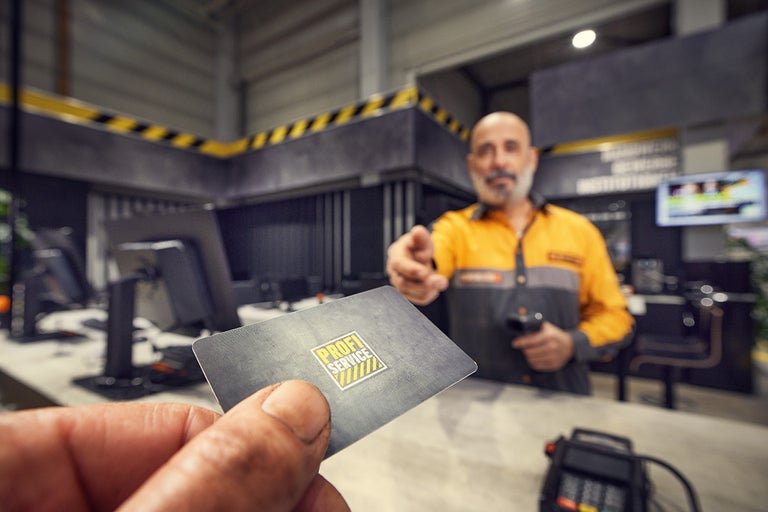 Hand houdt Profi Service Card vast bij een servicebalie