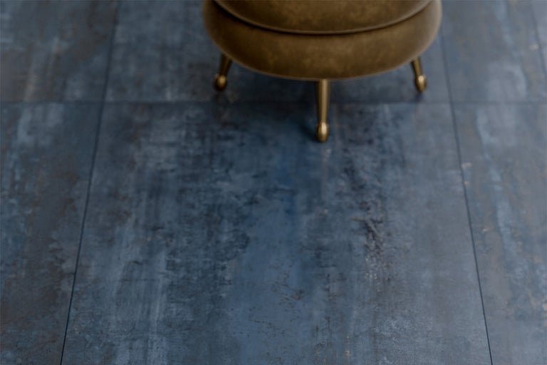 Blauw grijze vloertegels en een kruk met gouden poten