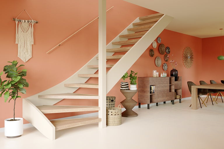 Lichte woonkamer met houten trap, dressoir en decoratie