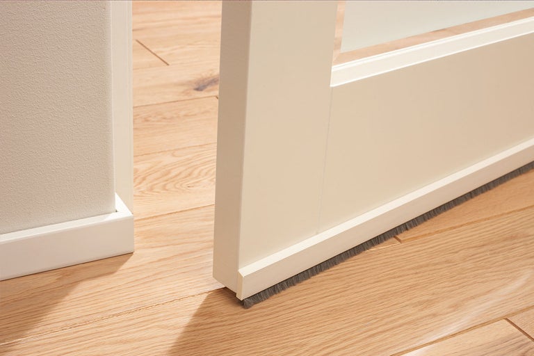 Detailopname van een binnendeur met een borstelafdichting aan de onderkant