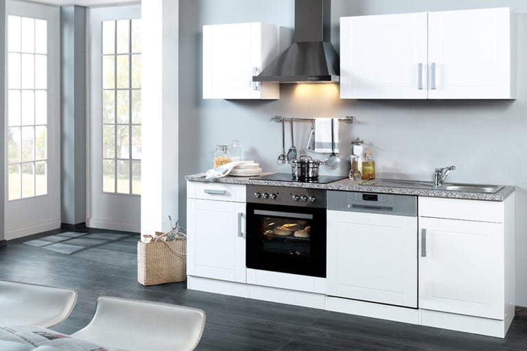 Lichte keuken met keukenkasten, gootsteen, fornuis, oven, afzuigkap en vaatwasser.
