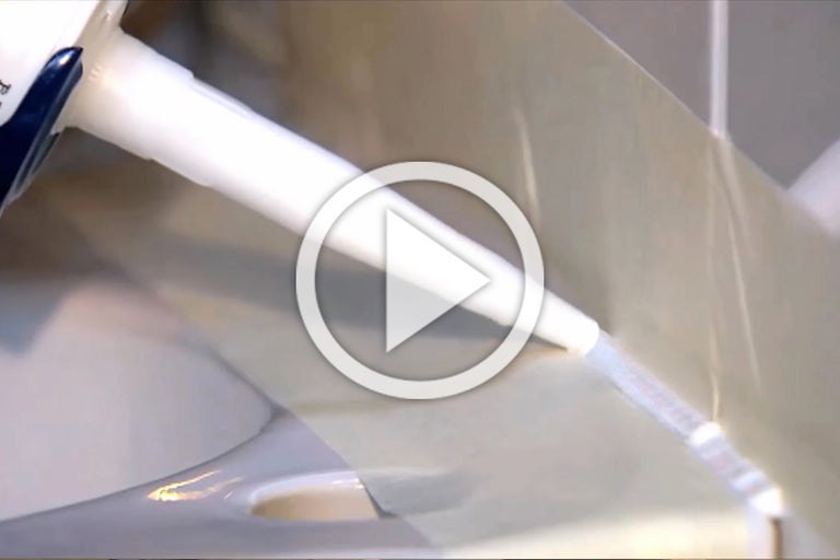 Aanbrengen van afdichtmiddel met een kitspuit in een badkamer.