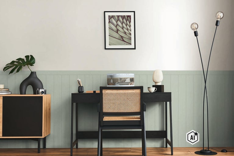 Modern thuiskantoor met zwart bureau, rotan stoel en een wand met verticale paneelbekleding in saliegroen.