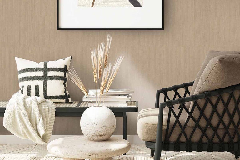 Woonkamerdecoratie met fauteuil, kussens, deken en gedroogde bloemen in een vaas