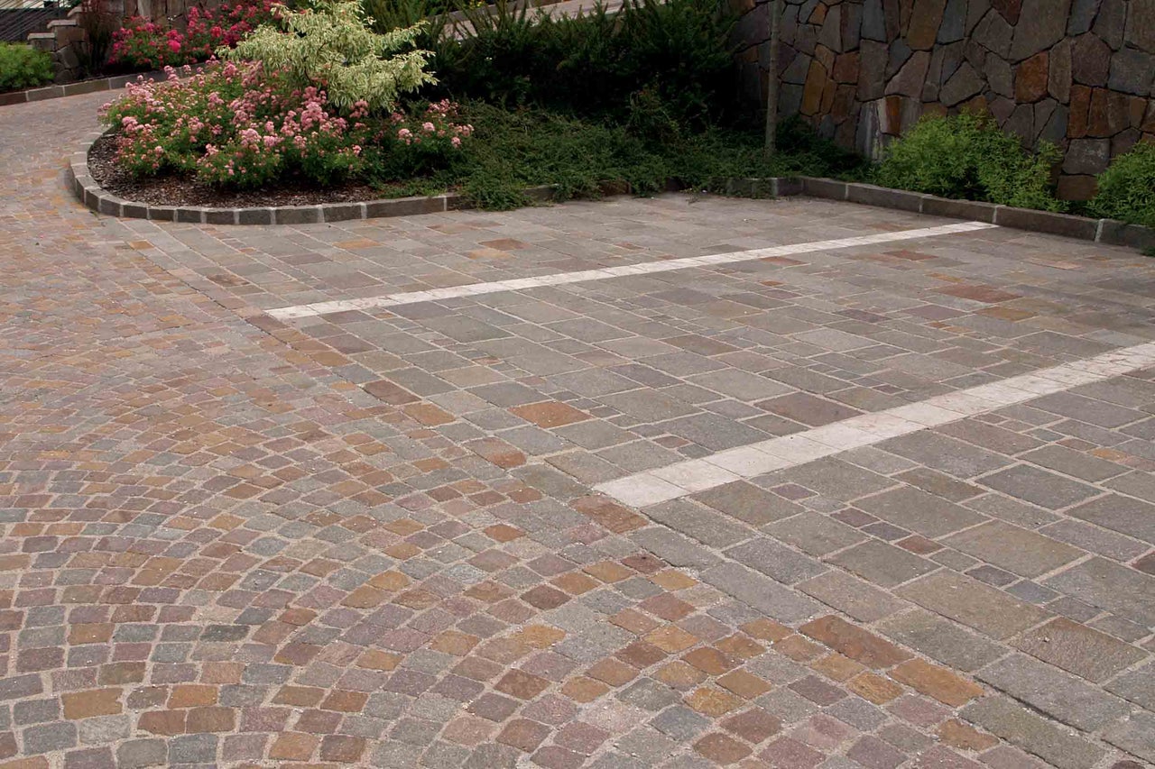 Bestrate oprit met verschillende steenpatronen en beplanting