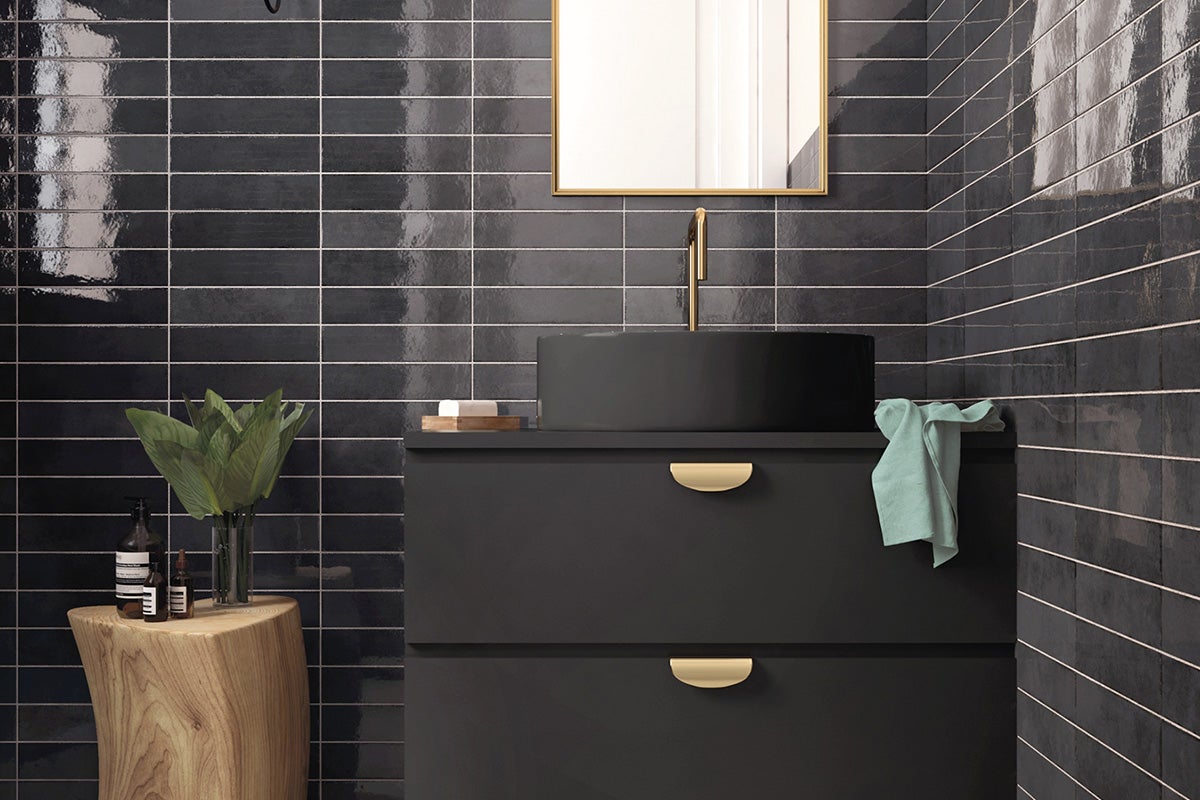 Moderne badkamer met zwarte tegels, wastafelmeubel en spiegel