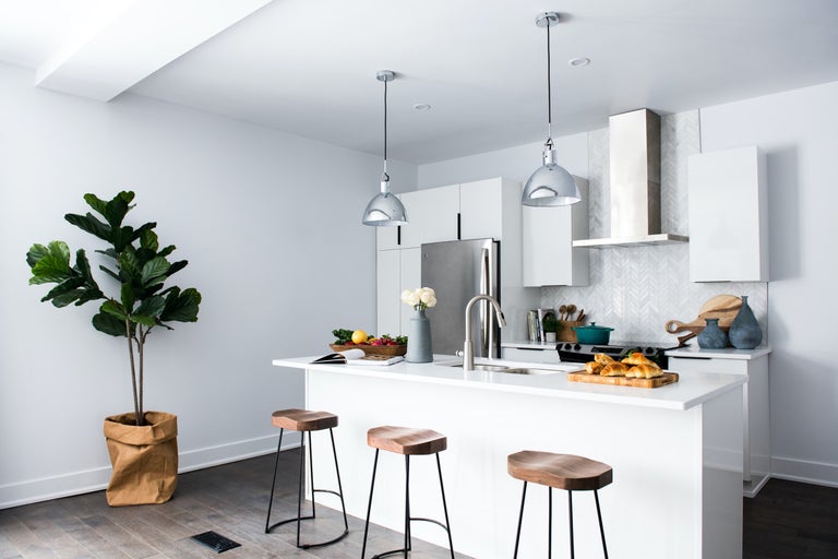 Lichte keuken met kookeiland, barkrukken en kamerplant