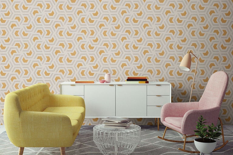 Woonkamer met geometrisch behang, gele fauteuil, roze schommelstoel en wit dressoir