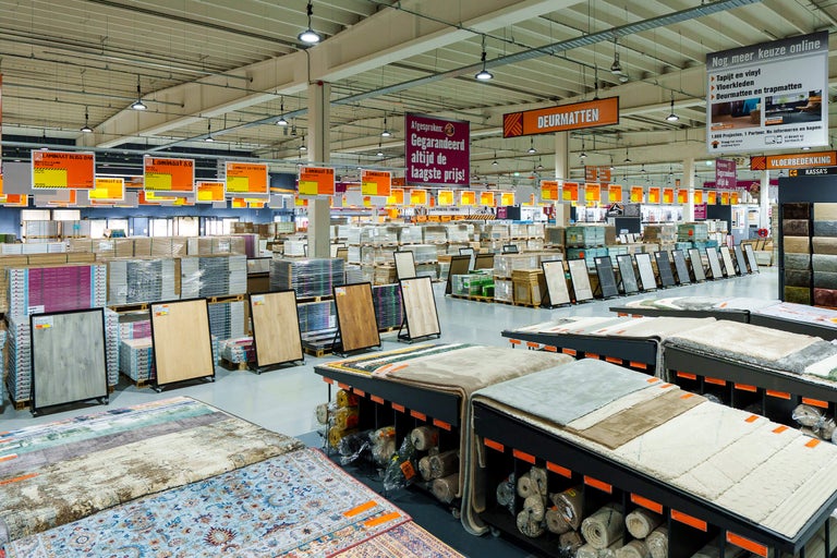 Overzicht van de vloerafdeling in een Hornbach vestiging met een ruim assortiment tapijten, laminaat en deurmatten.