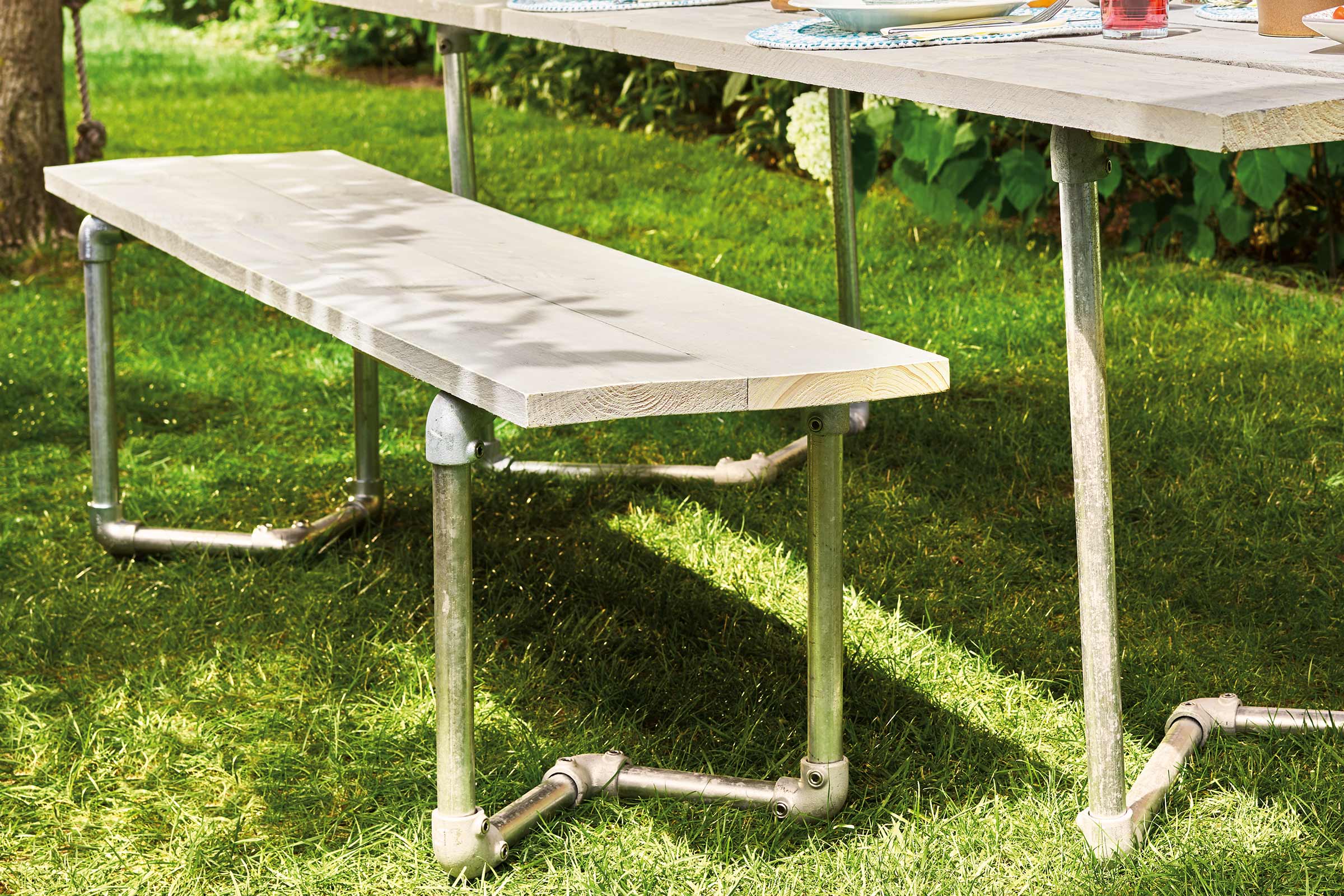 Houten bank met metalen poten in de tuin