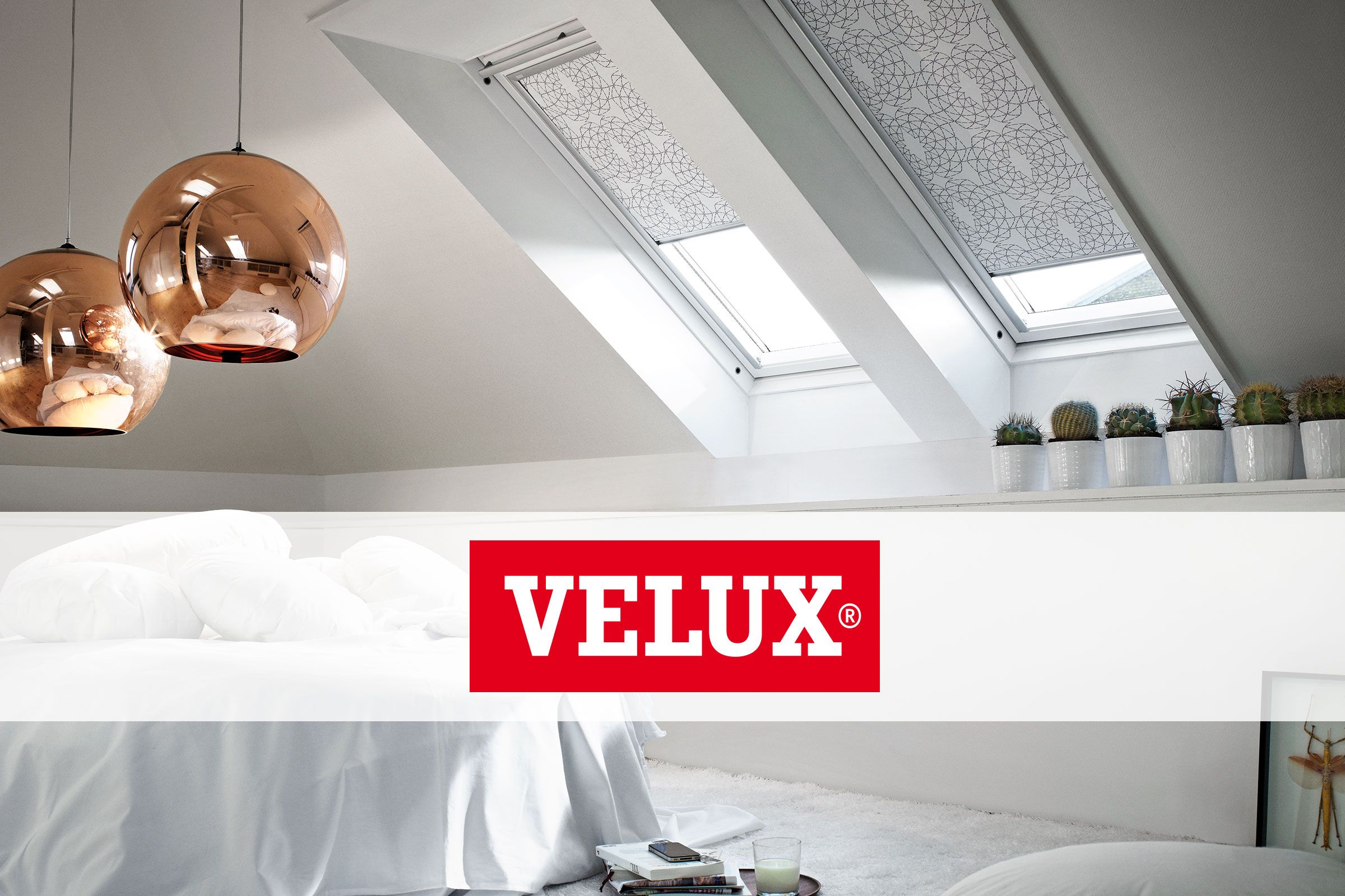 Slaapkamer met dakramen en verduisterende rolgordijnen, met daarboven het Velux logo.