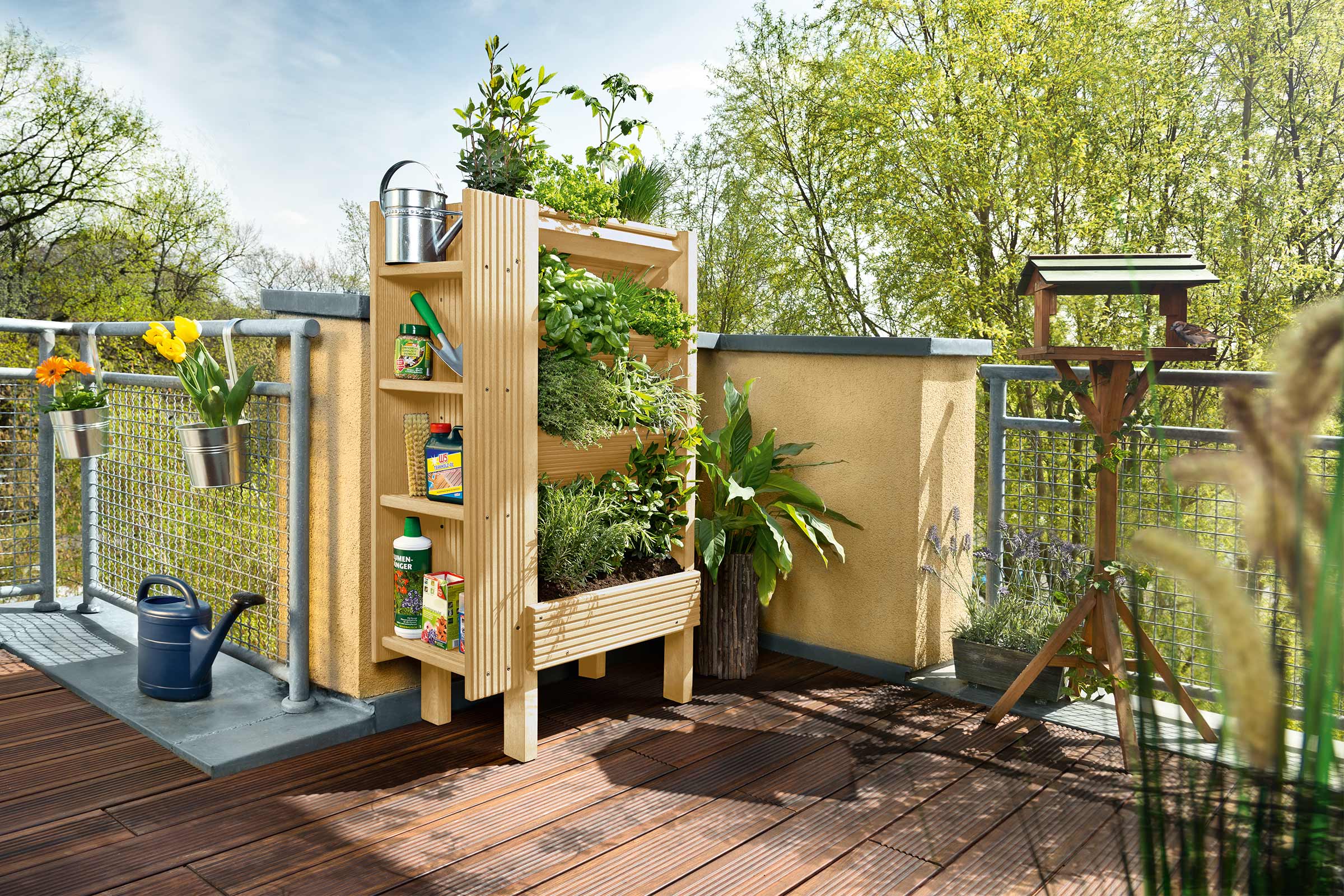 Balkon met plantenbak, vogelhuisje, bloembakken en gieter
