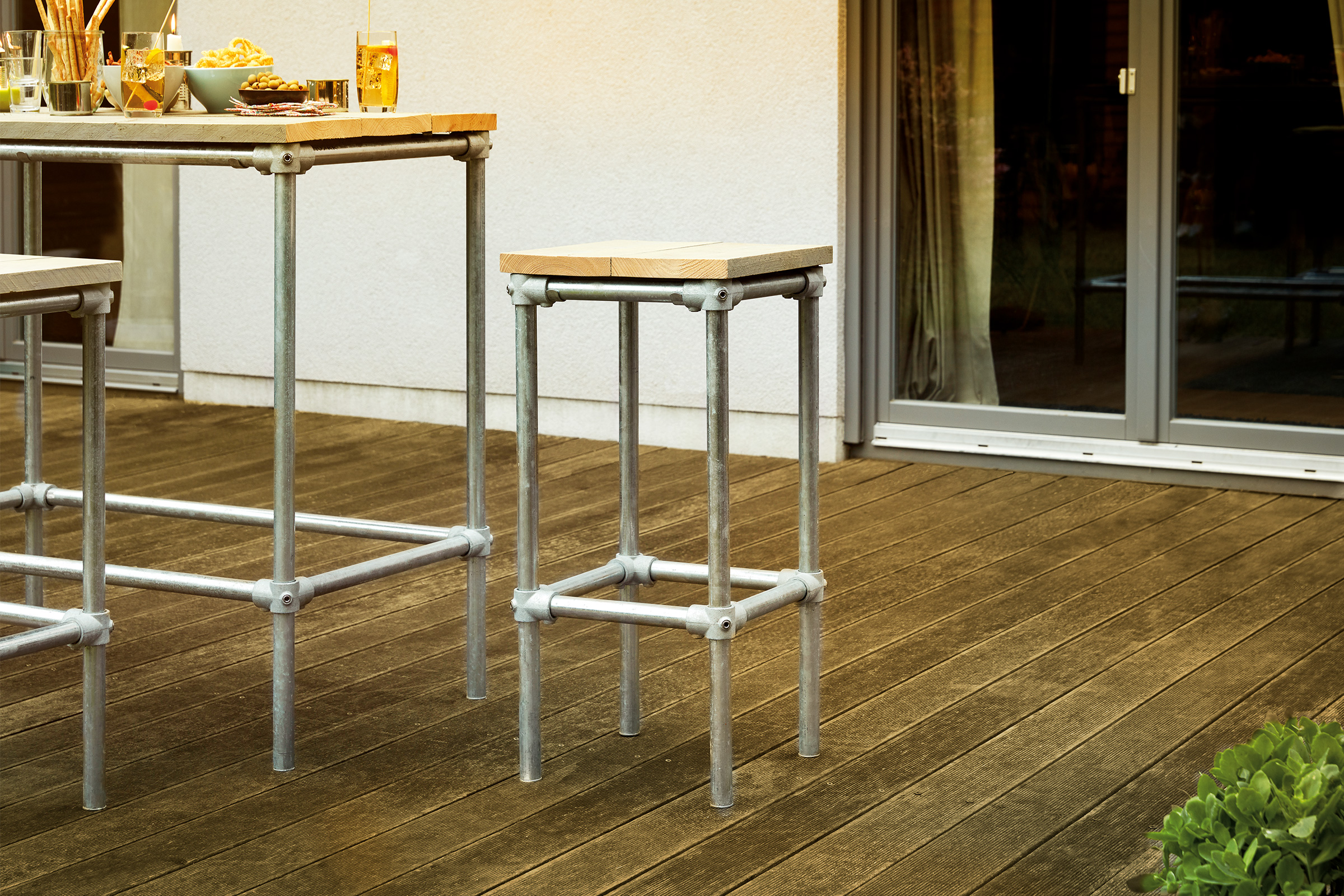Barkruk en bartafel met stalen frame en houten blad op een terras