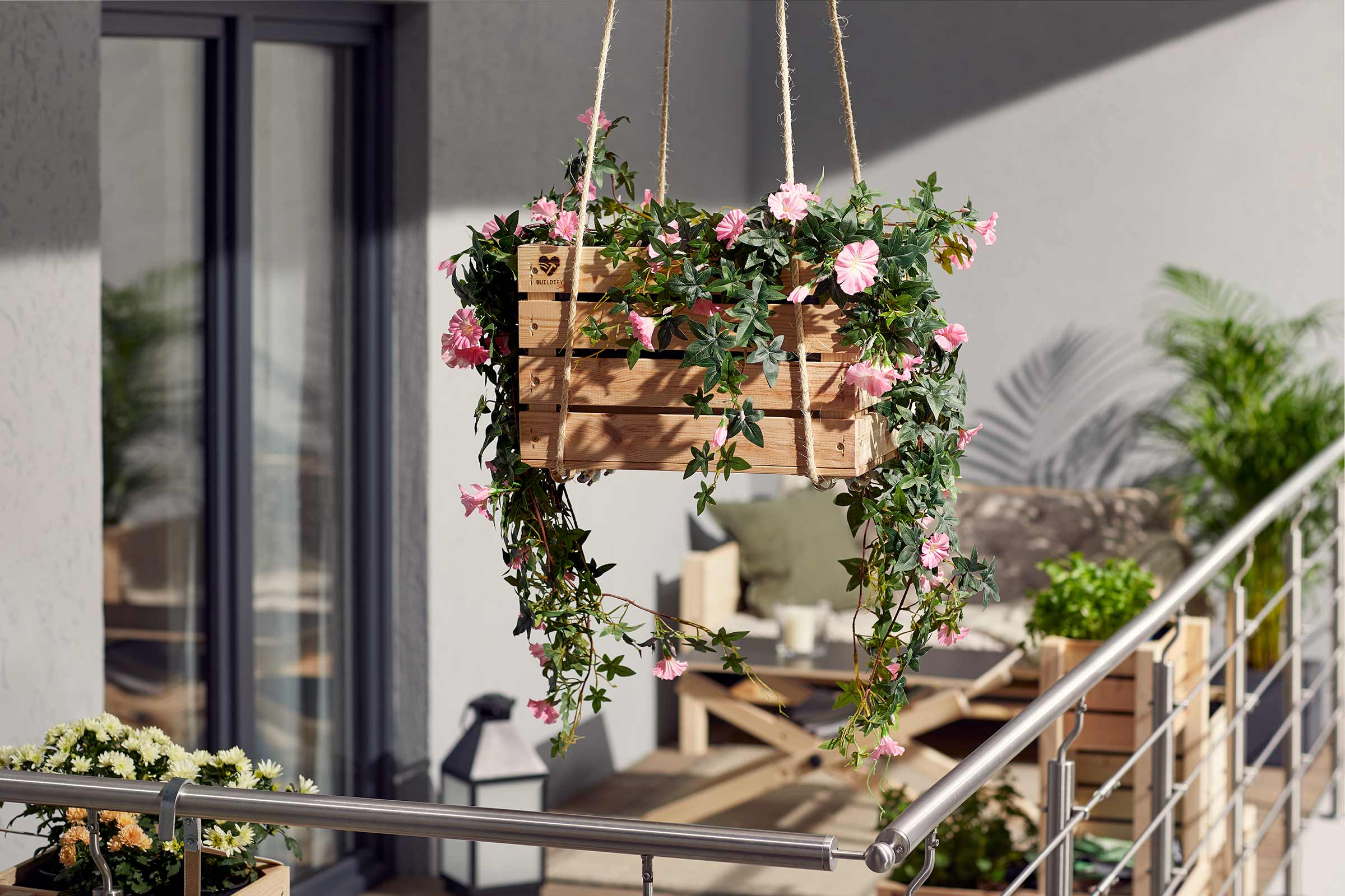 Hangende houten bak met roze bloemen en groene bladeren voor buiten.