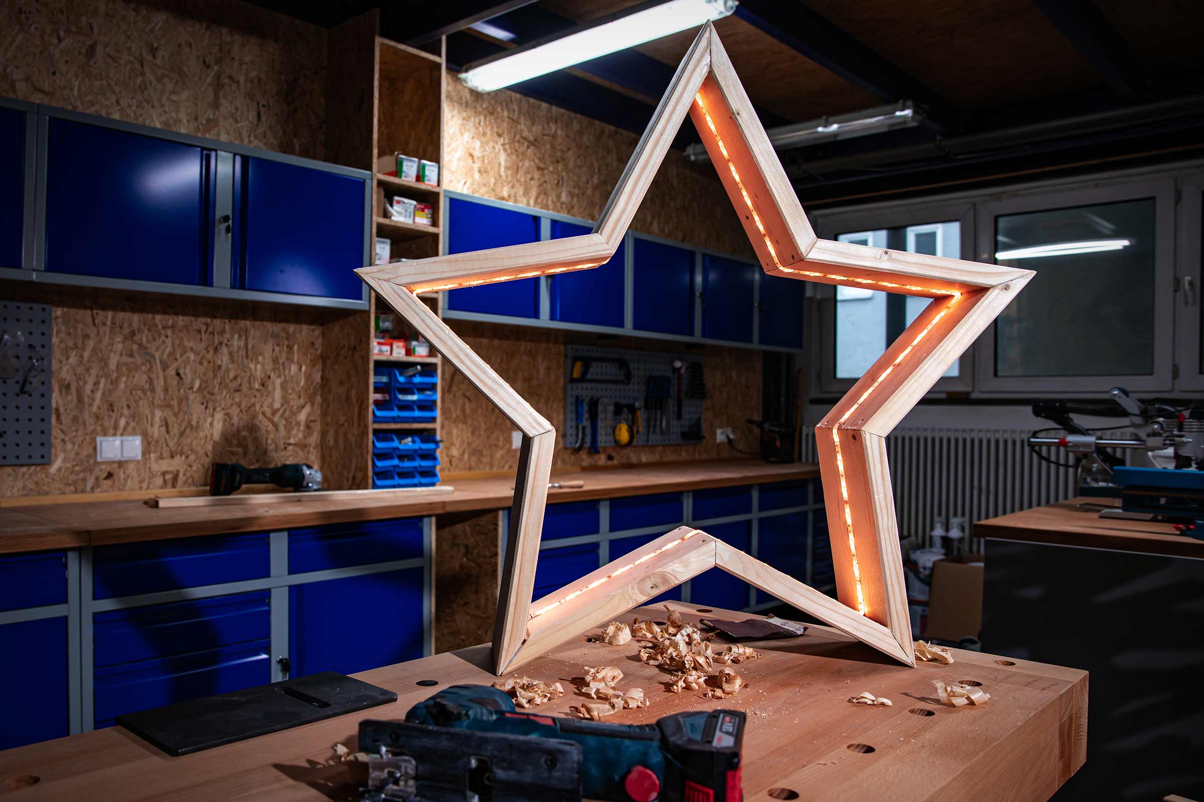 Decoratieve houten ster met verlichting in een werkplaats