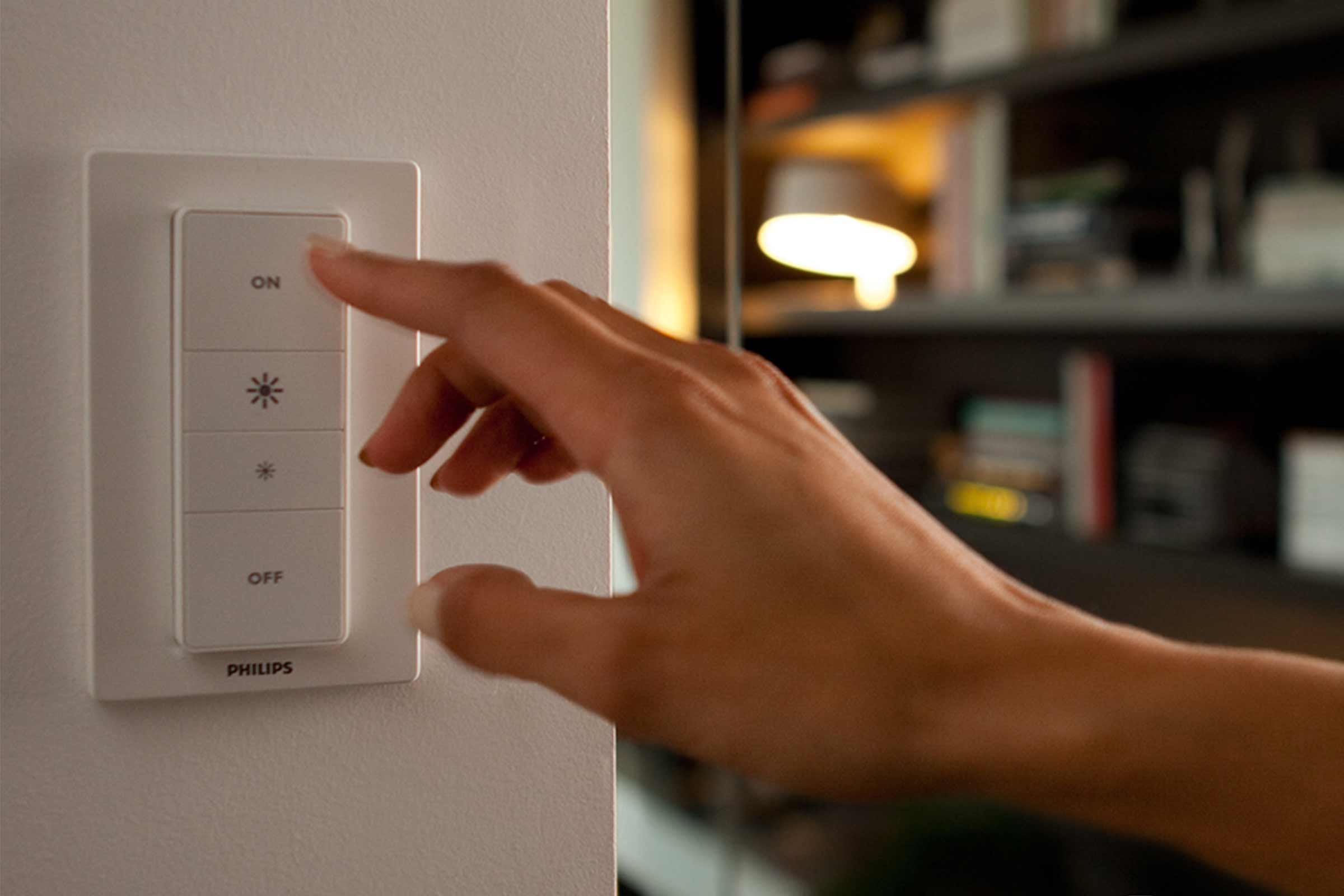Hand bedient Philips lichtschakelaar aan de muur