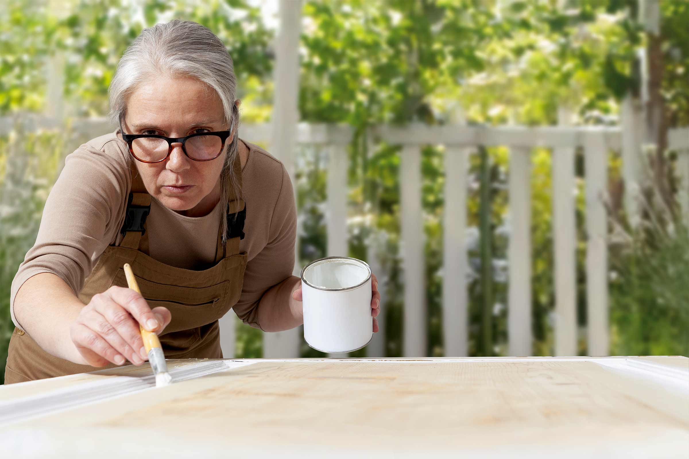 Vrouw schildert hout met verf en penseel