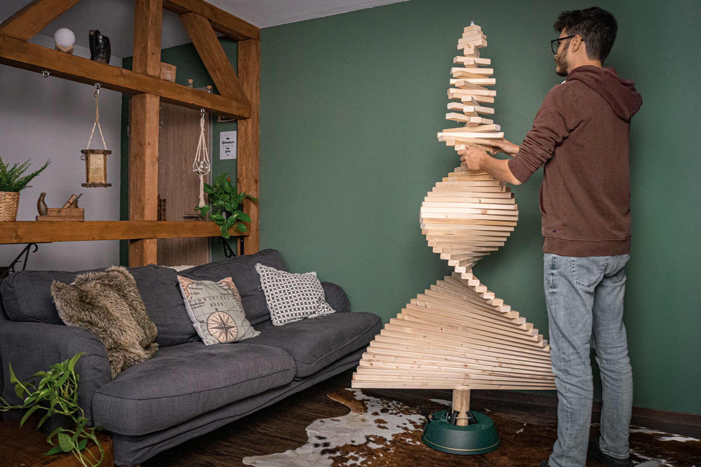 Man bouwt een houten design kerstboom in de woonkamer.