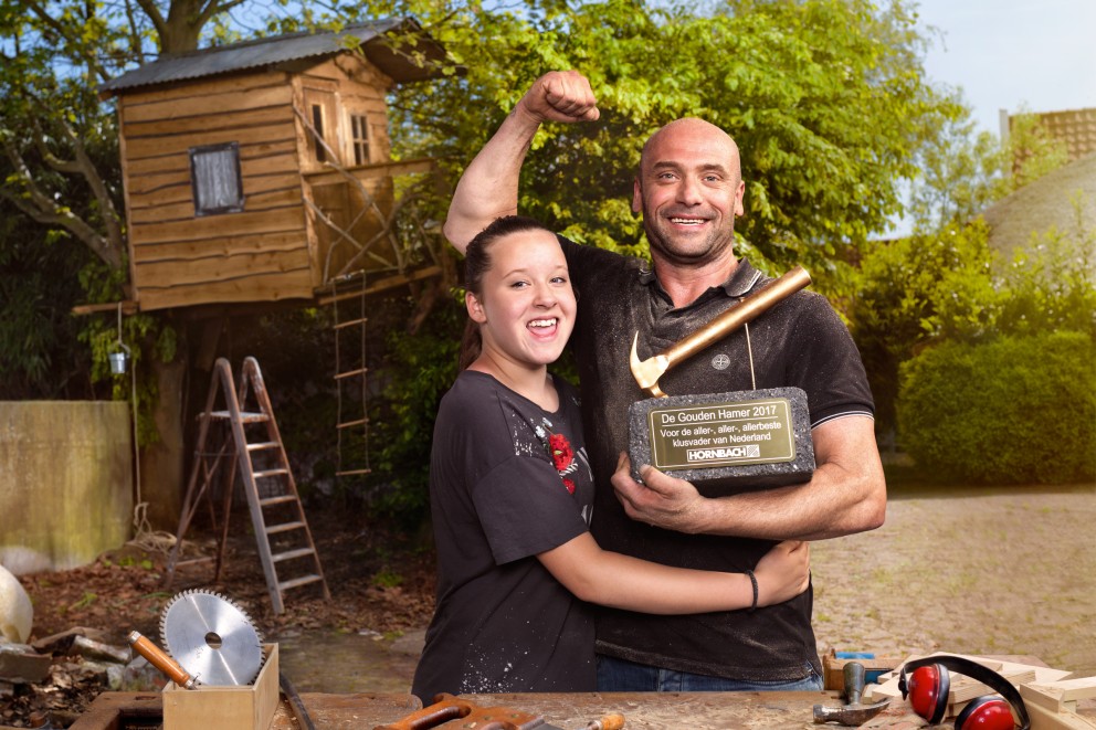 Scene met man, meisje en de Hornbach prijs 'Gouden Hamer' voor een boomhut
