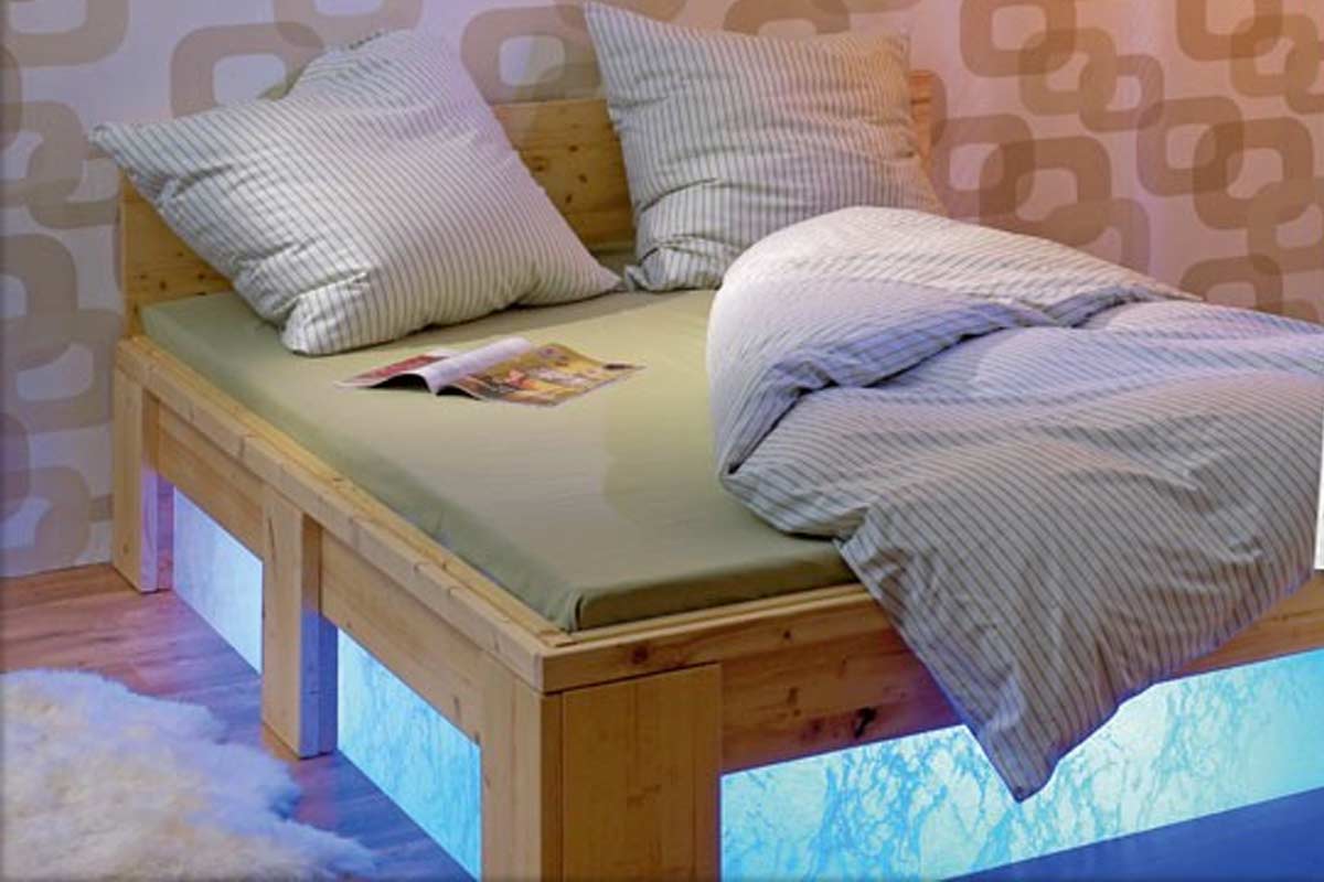Bed met lattenbodem, matras, kussens en dekbed in de slaapkamer