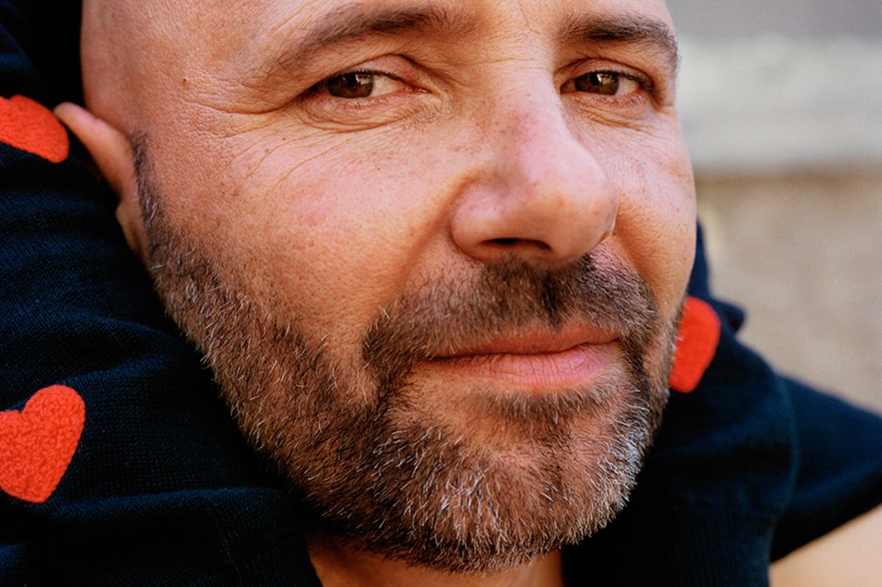 Close-up van een man met een baard en een top met hartmotieven